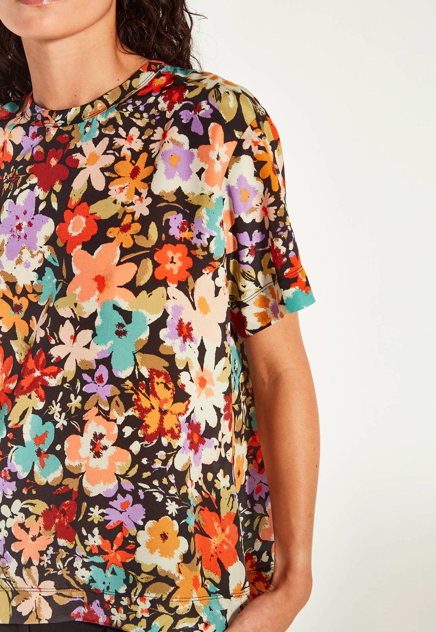 Person wearing a colorful floral-patterned shirt on a white background