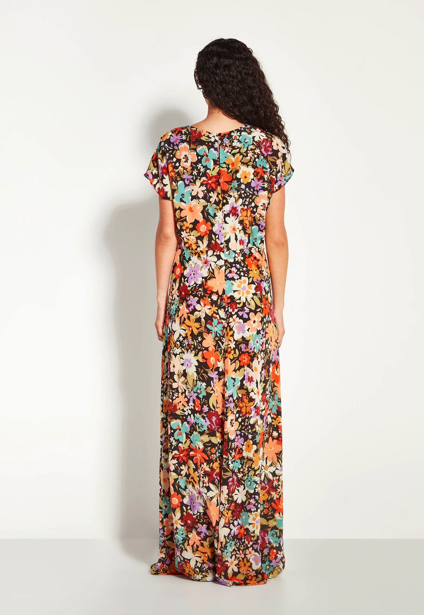Woman wearing a long floral dress against a white background