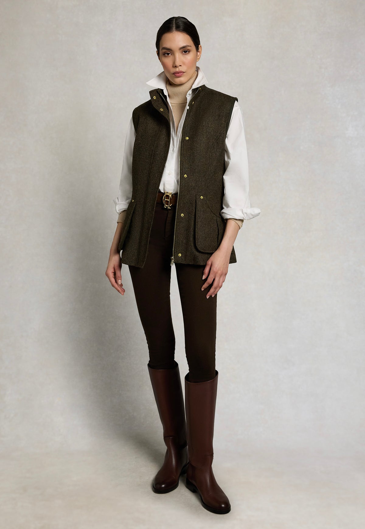 Holland Cooper Country Classic Tweed Gilet in Dark Green Herringbone, open, featuring patch pockets and a stand collar.