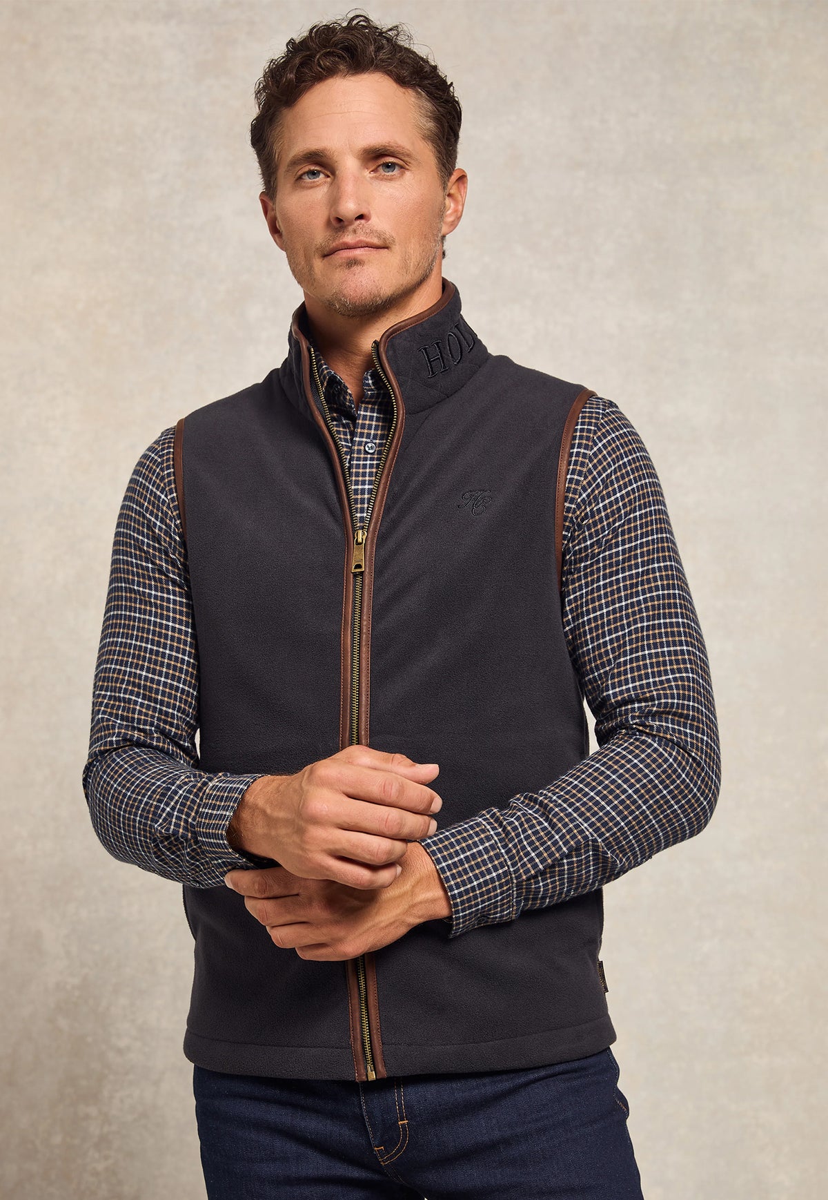 Holland Cooper Men’s Country Fleece Gilet in Ink Navy, navy polar fleece gilet with full zip, faux leather piping and HC chest embroidery.