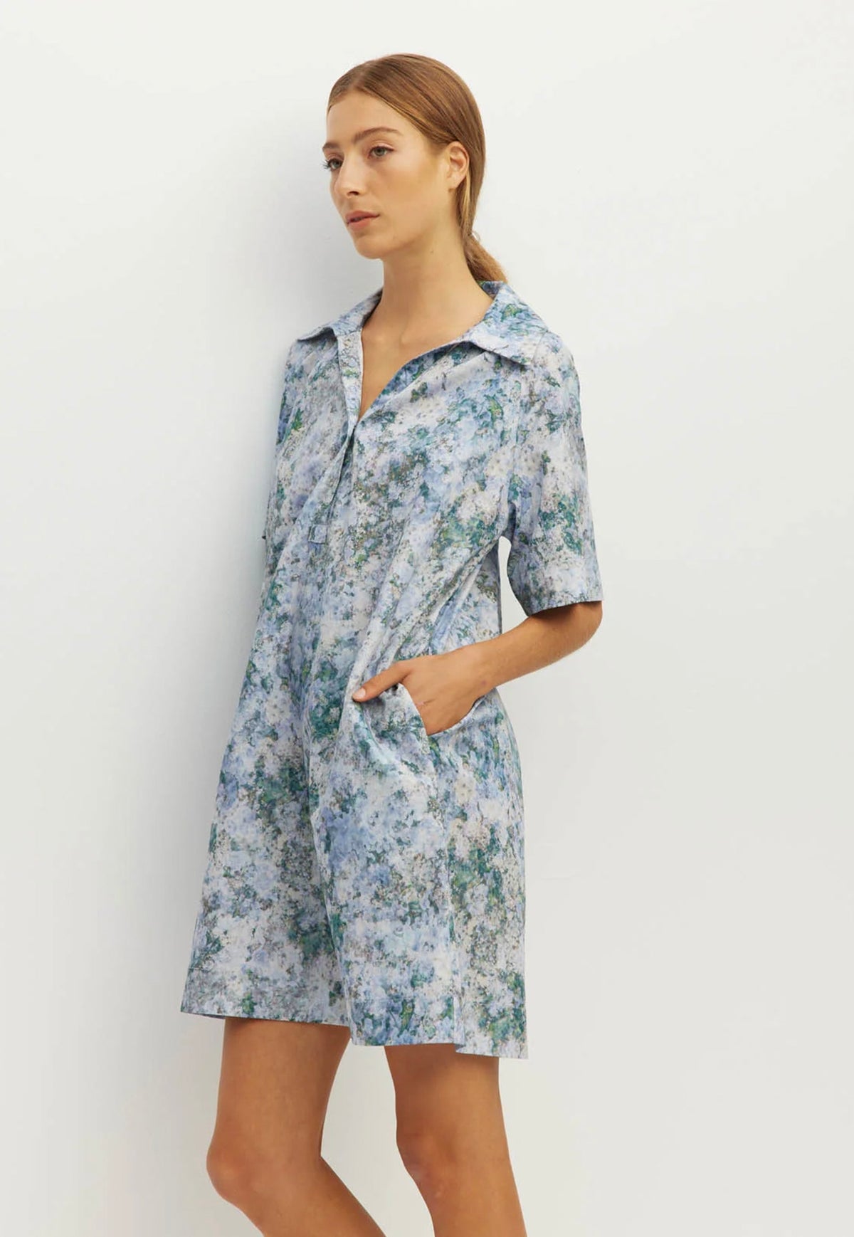 Side view of Juliette Hogan Rue Shirtdress in Cloud Flower Cotton Frosted Sky, relaxed printed cotton dress with collared neckline and elbow-length raglan sleeves.