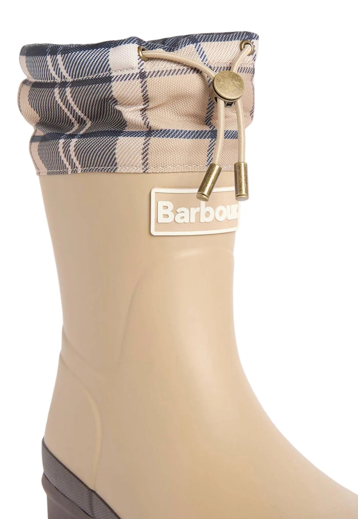 A close-up of a Barbour rain boot in beige, featuring a plaid fabric cuff in beige, navy, and white with brass-colored drawstring hardware.