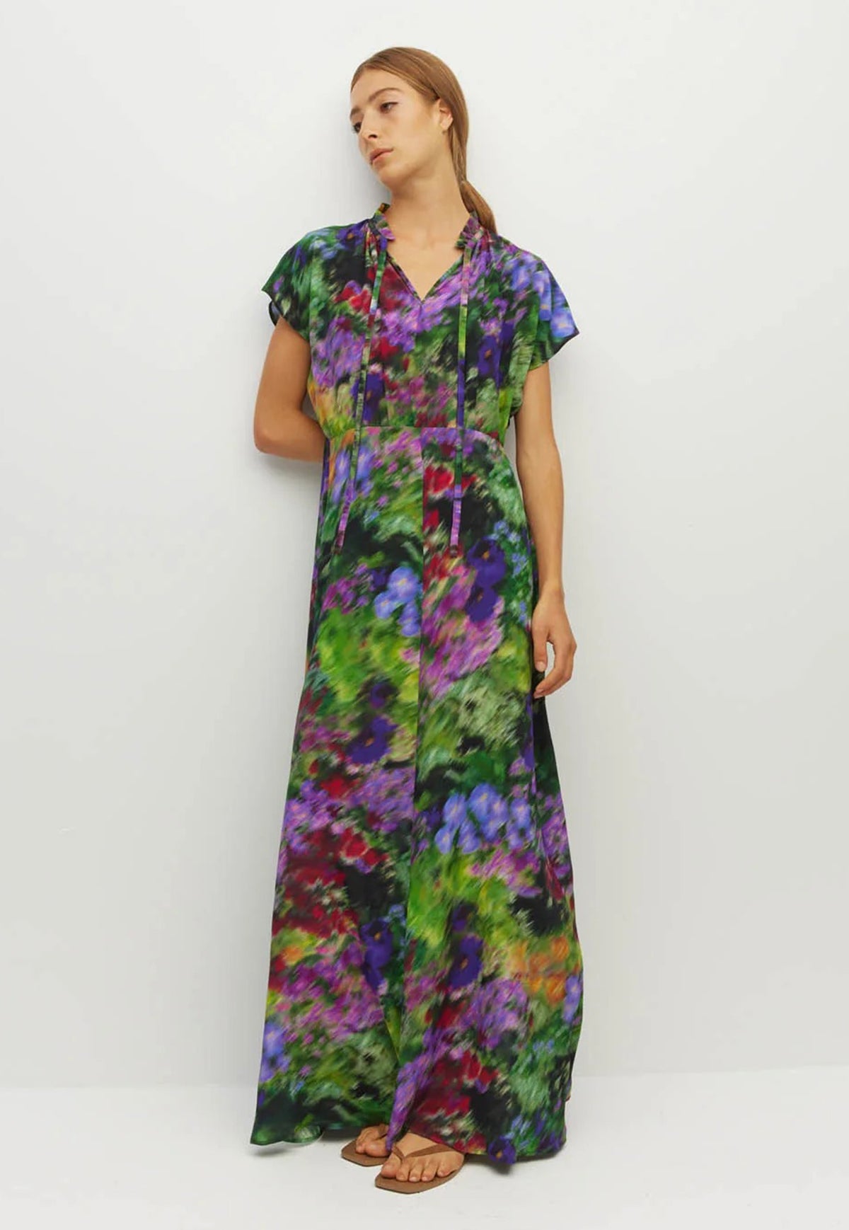 Juliette Hogan ruffle collar, short capped sleeve 70s inspired maxi dress with a vibrant, painterly floral print in green, purple, and blue.