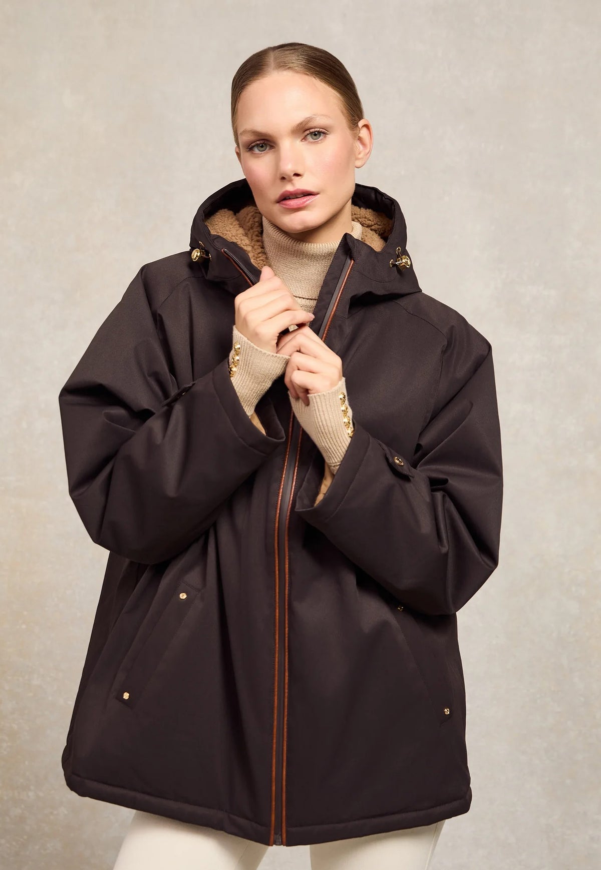 Holland Cooper One-Size Waterproof Jacket in Chocolate, dark brown oversized mid thigh length rain jacket with borg lined hood, faux leather piping and full zip.
